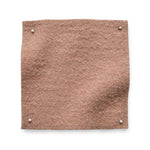 Wool boucle swatch pinned in all corners in soft pink.