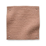 Wool boucle swatch pinned in all corners in soft pink.