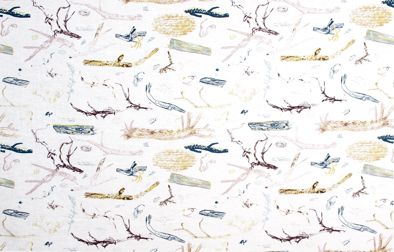Detail of fabric in a painterly tree branch print in shades of brown, yellow and blue on a white field.