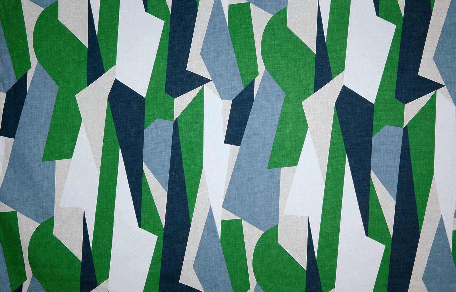 Detail of fabric in an abstract geometric print in blue, green, tan and white.