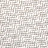 Detail of fabric in a dense geometric print in gray, white and cream.
