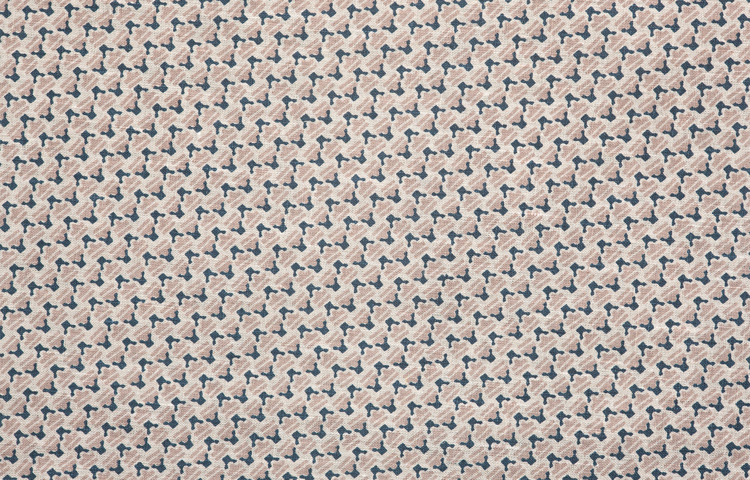 Detail of fabric in a dense geometric print in navy, tan and cream.