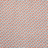 Detail of fabric in a dense geometric print in red, blue and cream.