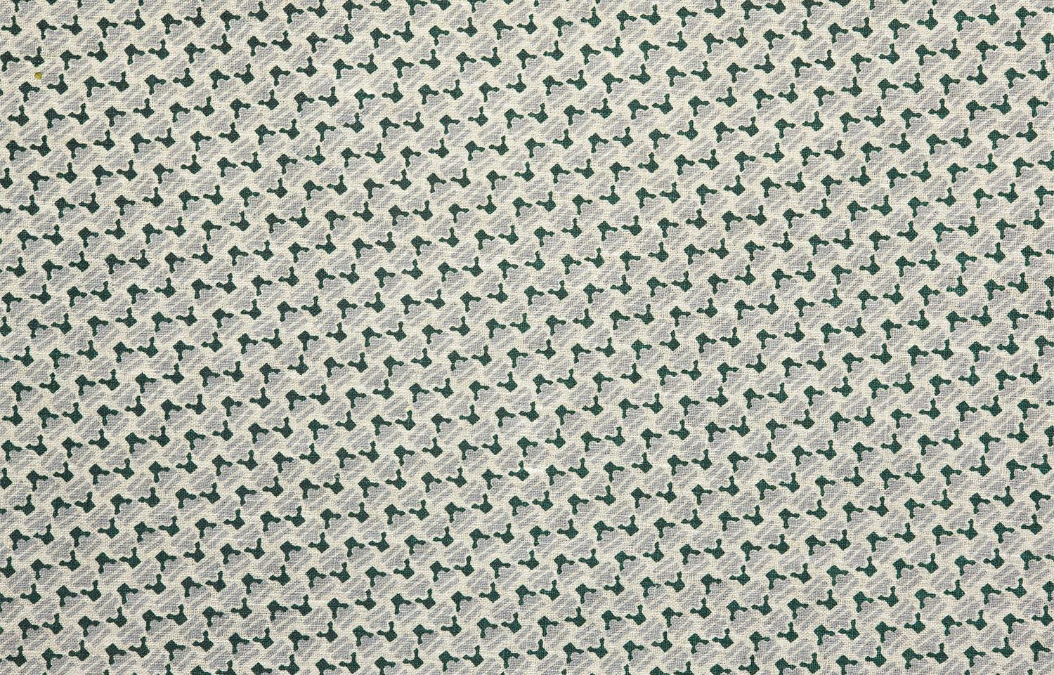 Detail of fabric in a dense geometric print in gray, dark green and cream.