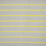 Detail of fabric in a horizontal striped print in yellow and white on a tan field.