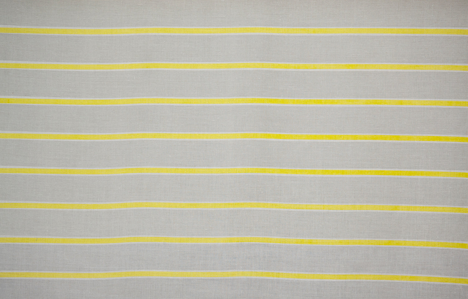 Detail of fabric in a horizontal striped print in yellow and white on a tan field.