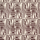 Detail of fabric in a dense geometric print in brown on a cream field.