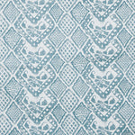 Detail of fabric in a lacey diamond print in white on a blue-gray field.