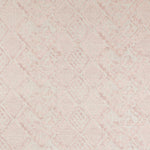 Detail of fabric in a lacey diamond print in cream on a mottled pink field.
