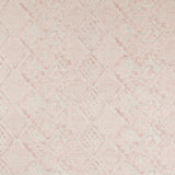 Detail of fabric in a lacey diamond print in cream on a mottled pink field.