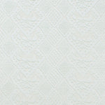 Detail of fabric in a lacey diamond print in white.