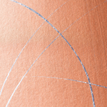 Wide-angle shot of wallpaper in an abstract curved line pattern in metallic silver on an orange field.