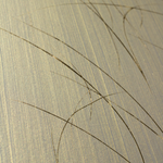 Wide-angle shot of wallpaper in an elongated paint splatter pattern in gold on a metallic field.
