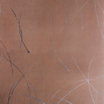 Detail of a wallpaper in an elongated paint splatter pattern in metallic navy on a rust field.