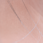 Wide-angle shot of wallpaper in an abstract curved line pattern in silver on a pink field.