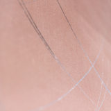 Wide-angle shot of wallpaper in an abstract curved line pattern in silver on a pink field.