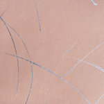 Detail of a wallpaper in an abstract curved line pattern in metallic silver on a pink field.