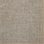 Close-up of a textured beige broadloom carpet with a subtle pattern