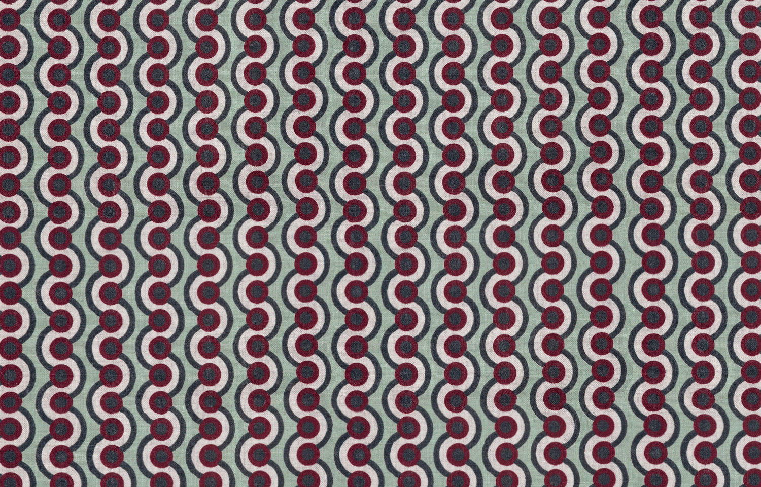 Detail of fabric in a playful curving stripe print in red, white and green on a light green field.