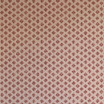 Detail of wallpaper in a minimalist quatrefoil pattern in red on a cream field.