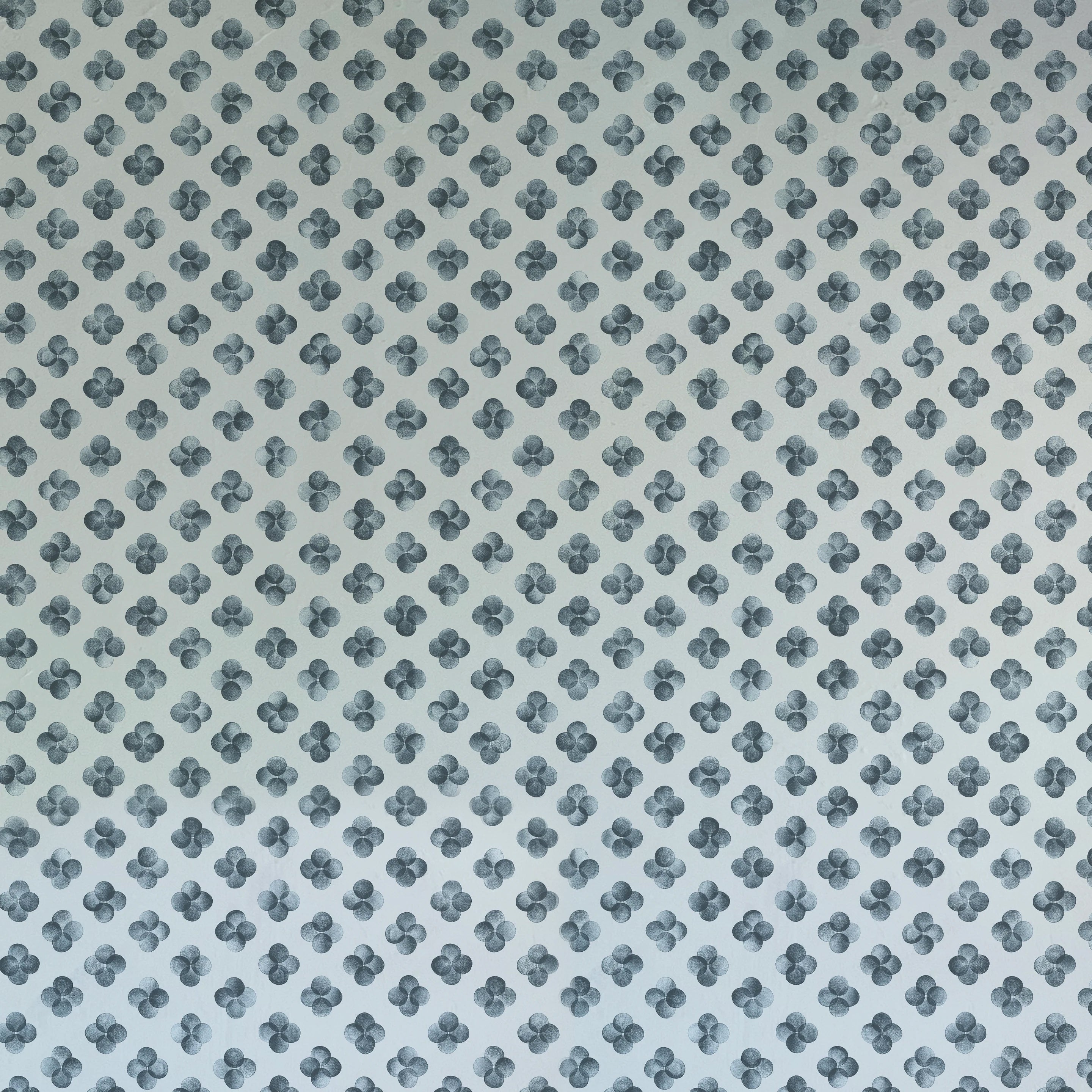Detail of wallpaper in a minimalist quatrefoil pattern in navy on a light blue field.