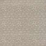 Detail of fabric in a dense petal print in shades of tan on a white field.
