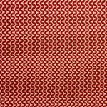 Detail of fabric in a playful curving stripe in red on an orange field.
