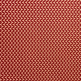 Detail of fabric in a playful curving stripe in red on an orange field.