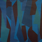 Detail of fabric in an abstract geometric print in blue, green and brown.