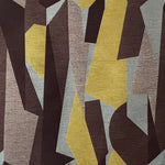 Detail of fabric in an abstract geometric print in brown, yellow, tan and gray.