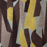 Detail of fabric in an abstract geometric print in brown, yellow, tan and gray.