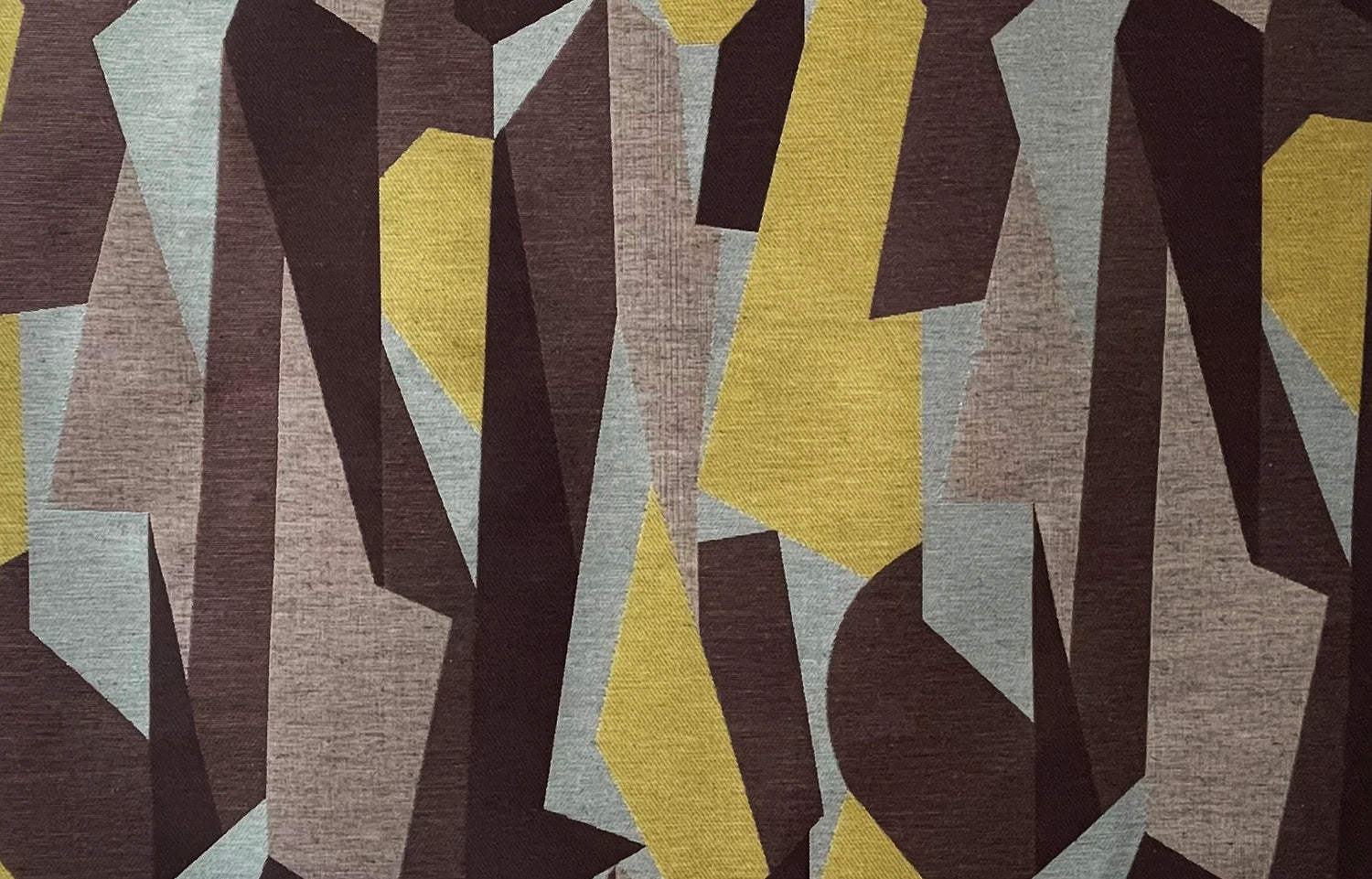 Detail of fabric in an abstract geometric print in brown, yellow, tan and gray.