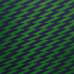 Detail of fabric in a zigzag stripe print in navy on a green field.