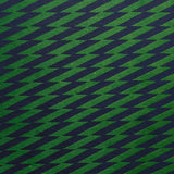 Detail of fabric in a zigzag stripe print in navy on a green field.