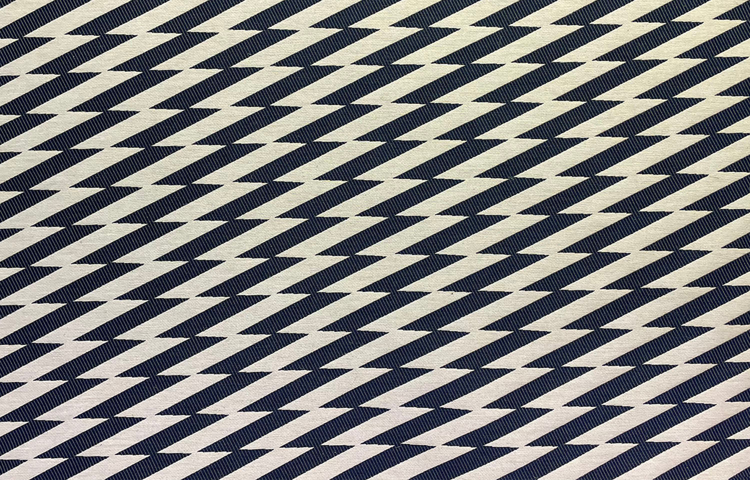 Detail of fabric in a zigzag stripe print in black on a cream field.