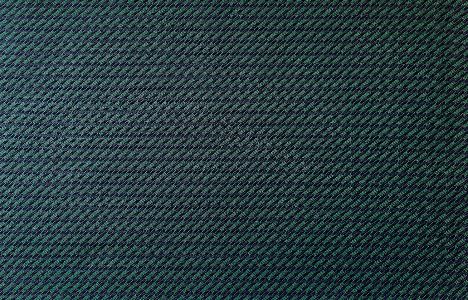 Detail of fabric in a matchstick grid print in navy on a dark green field.