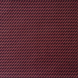 Detail of fabric in a matchstick grid print in black on a red field.