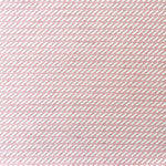 Detail of fabric in a matchstick grid print in pink on a white field.