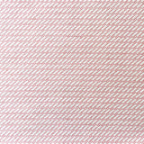 Detail of fabric in a matchstick grid print in pink on a white field.