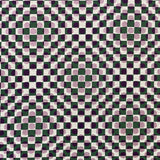 Detail of fabric in a geometric check and polka dot pattern in pink, black, cream and green.