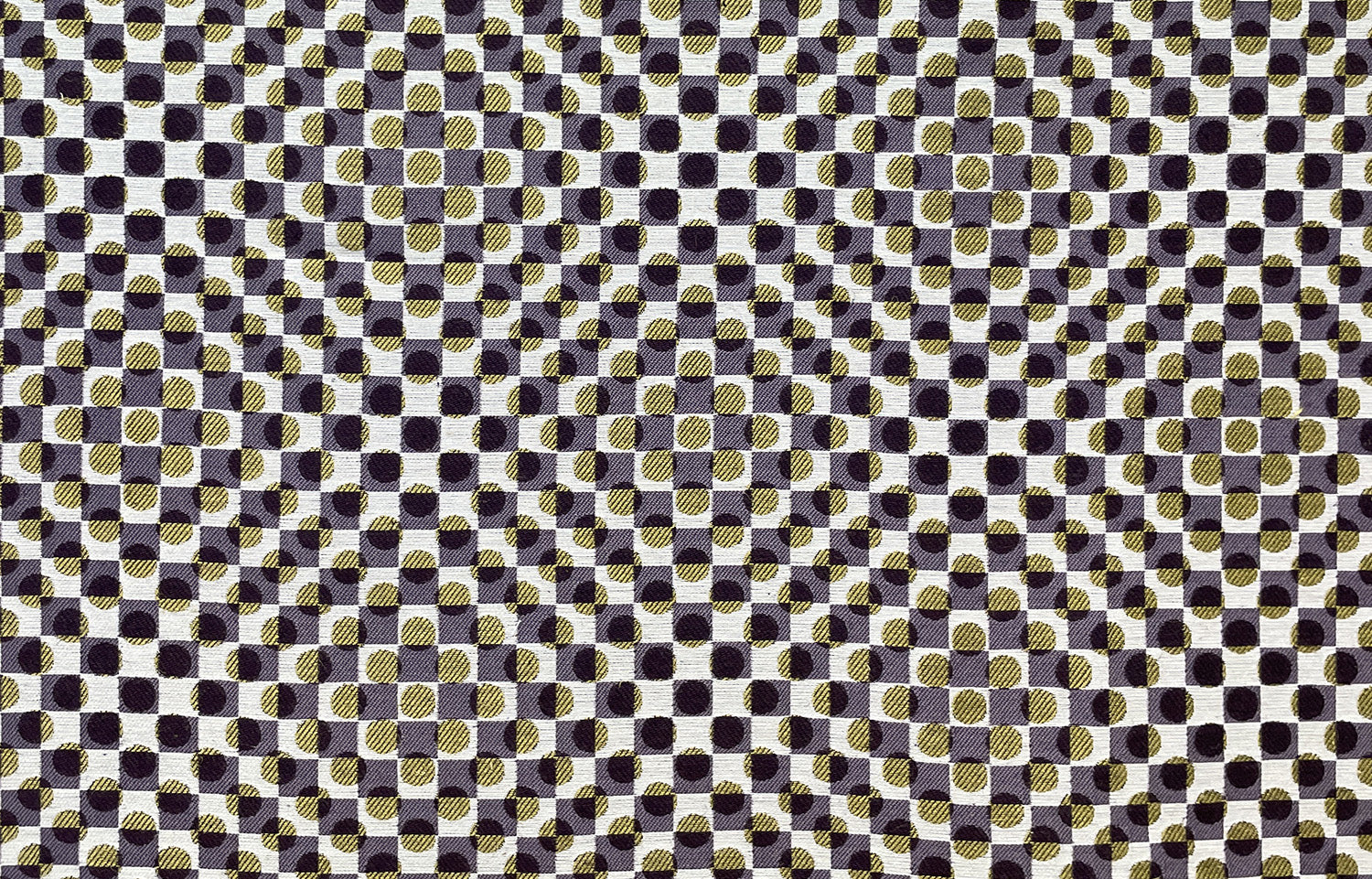 Detail of fabric in a geometric check and polka dot pattern in purple, gold, cream and black.