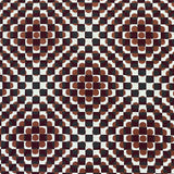 Detail of fabric in a geometric check and polka dot pattern in burnt orange, green, cream and black.