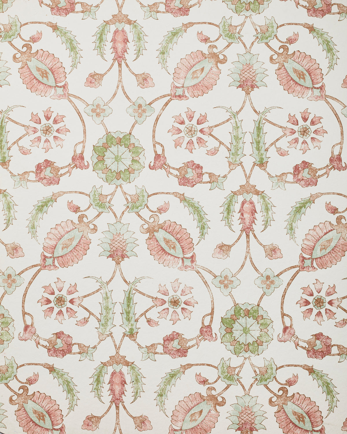 Detail of wallpaper in a floral paisley print in shades of rust and green on a cream field.