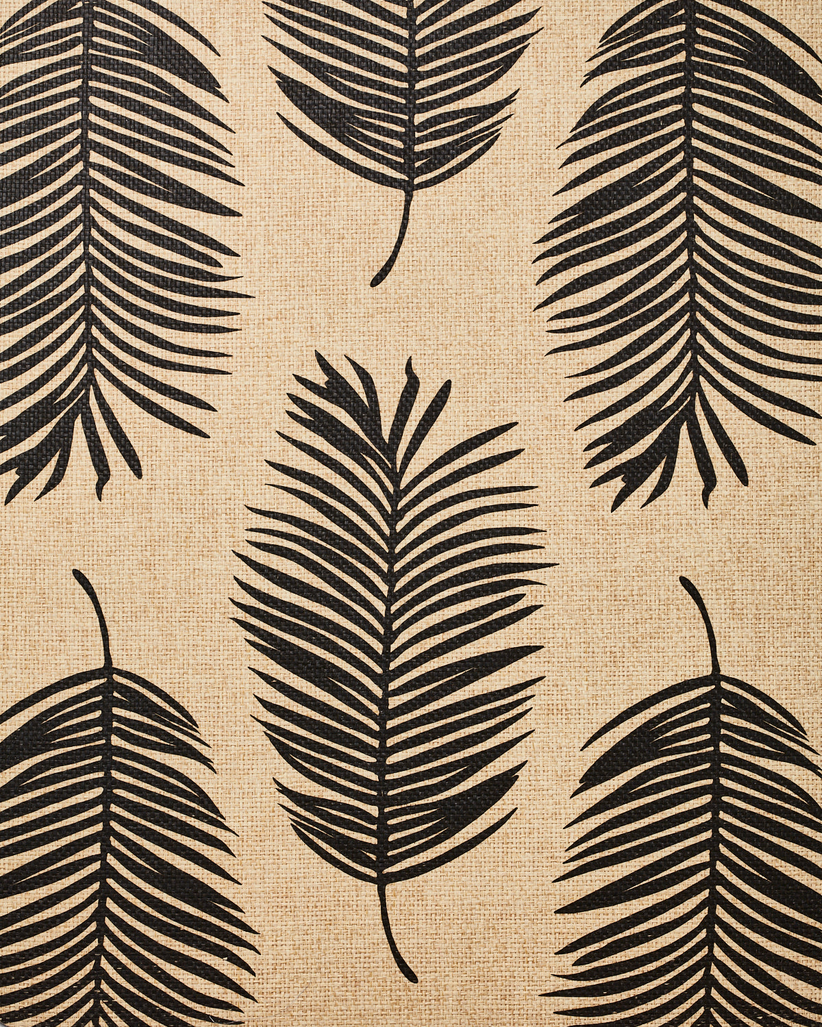 Detail of fabric in a large-scale leaf print in black on a tan field.
