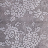 Detail of wallpaper in a minimalist floral print in light gray on a mottled gray field.
