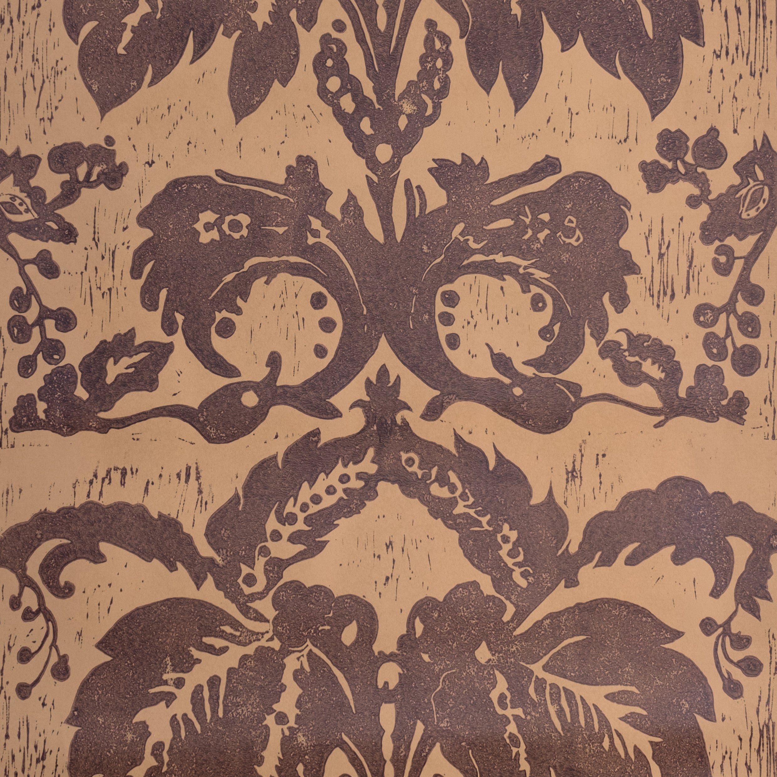 Detail of wallpaper in a repeating floral damask pattern in brown on a tan field.