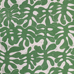 Detail of wallpaper in a playful repeating leaf print in green on a cream field.
