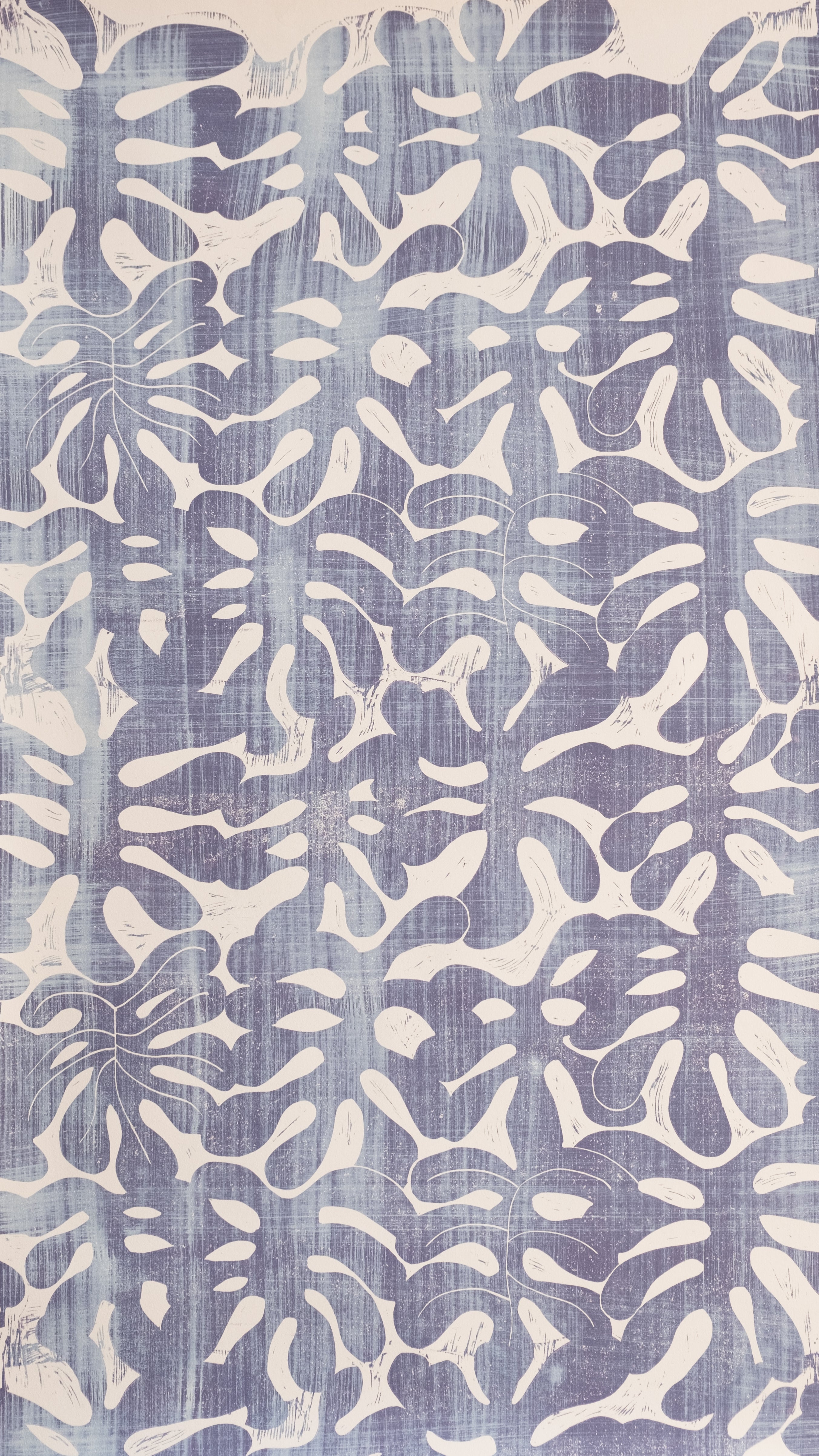 Detail of wallpaper in a playful repeating leaf print in mottled purple on a cream field.