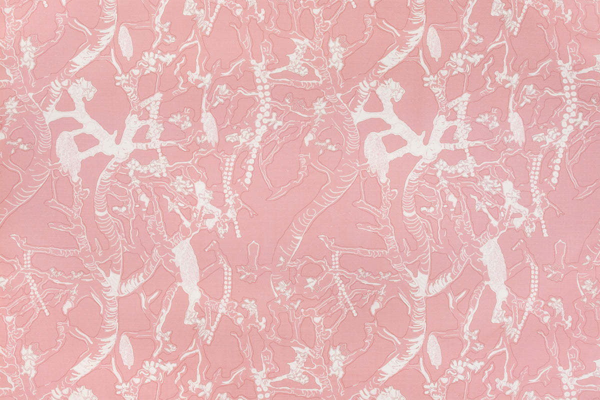 Detail of fabric in a branch and blossom print in cream and pink on a pink field.