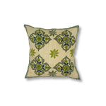 Throw pillow with printed and embroidered design in a floral medallion in blue and green. 